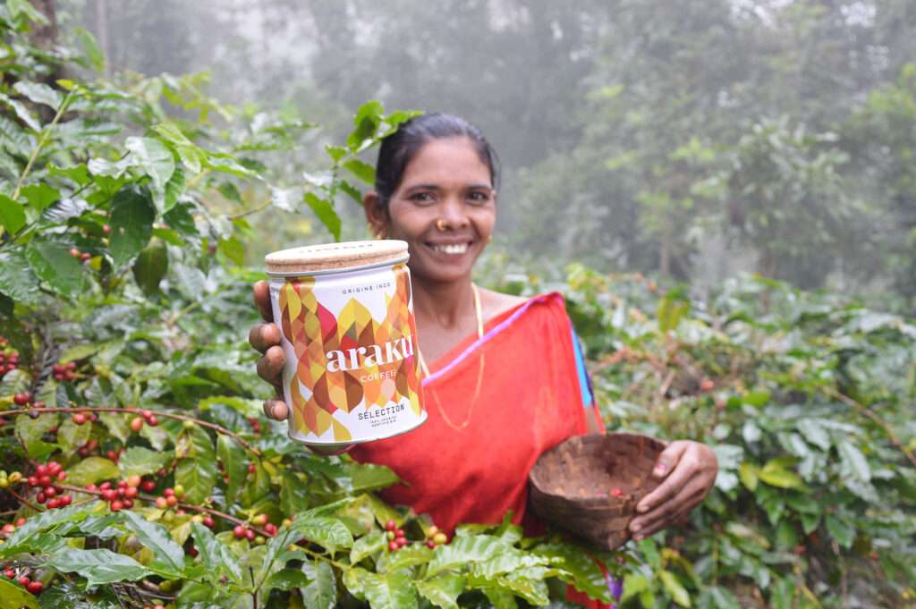 Women showing the Sustainable Araku Coffee Can in an coffee field