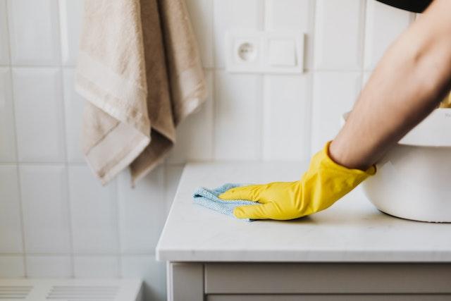 image of a person cleaning a sink surface using cleaners made from coffee grounds.